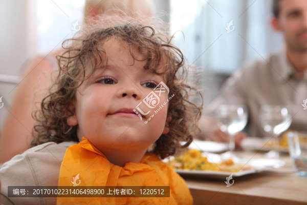 可愛的小孩和父母一起吃晚飯