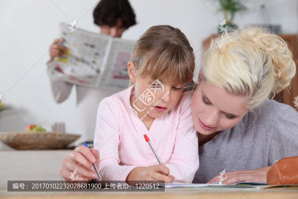 媽媽幫助女兒做作業(yè)。