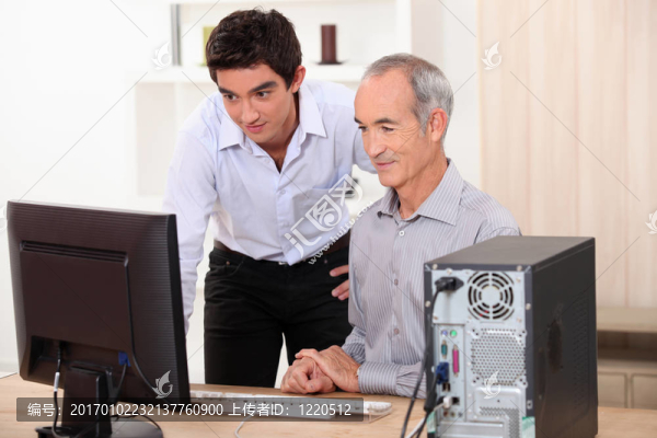 祖父和孫子在電腦上一起工作