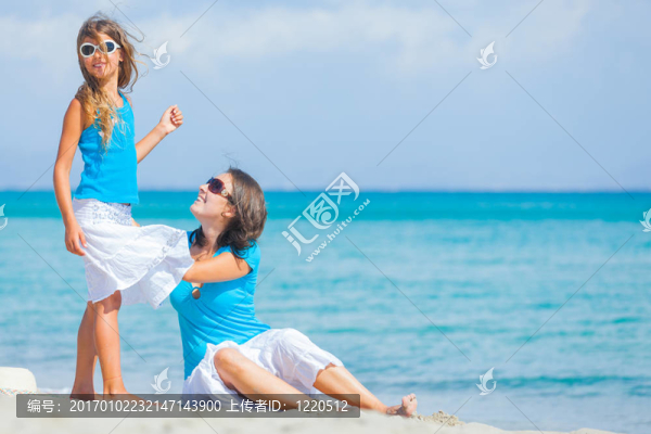 母親和她的小女兒在海灘上