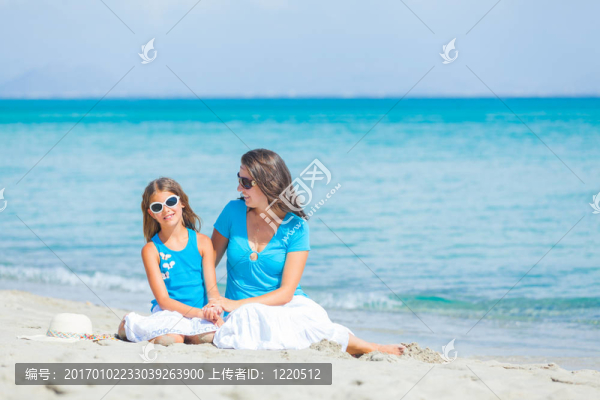 母親和她的小女兒在海灘上