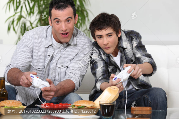 爸爸和兒子玩電腦游戲和吃垃圾食品