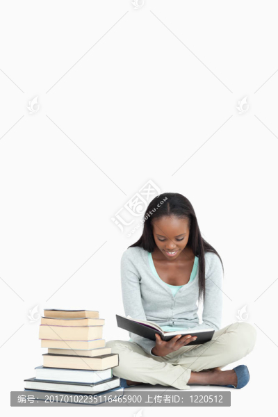 年輕女子閱讀旁邊的一堆書