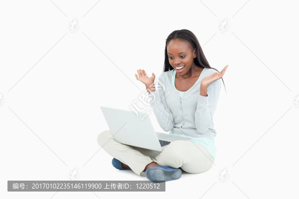 年輕女子在地板上積極驚訝她的筆記本電腦
