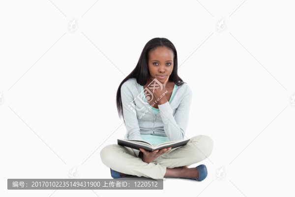 年輕女子坐在地板上想著她的書