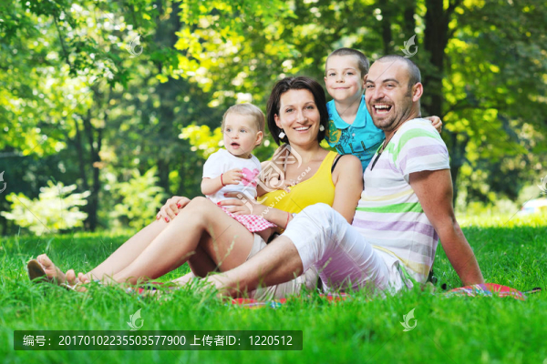 快樂的年輕夫婦和他們的孩子在公園玩得開心