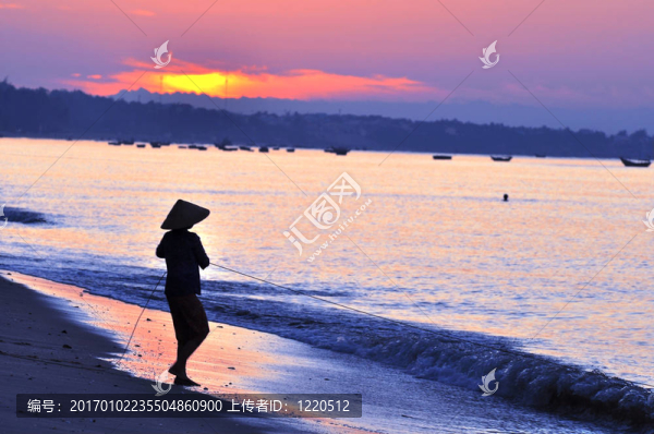 日出海灘上漁夫的剪影