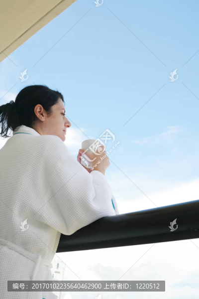 女人用早晨的咖啡穿過陽(yáng)臺(tái)