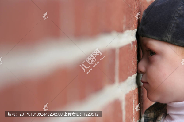 可愛(ài)的孩子用鼻子壓扁在磚墻