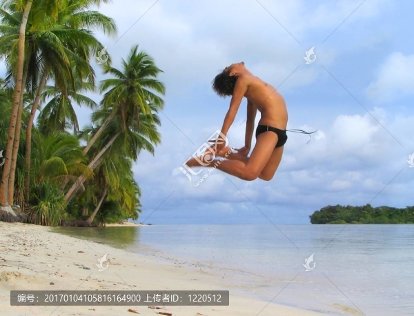 亞洲男孩歡呼在熱帶海灘跳舞