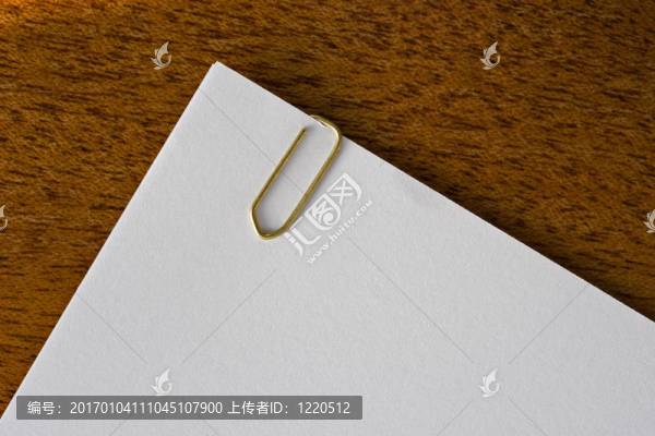 空白paperclipped頁躺在一張木制的桌子。