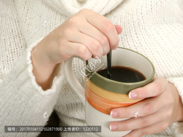 女人手里拿著一大杯咖啡和Spoon