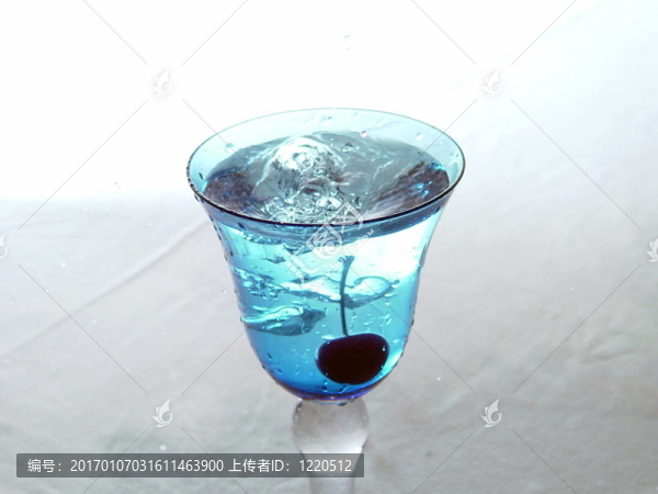 剛掉的櫻桃在藍(lán)色的玻璃