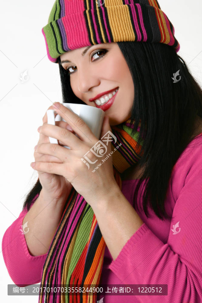 一個(gè)冬天風(fēng)格的女人拿著一個(gè)咖啡杯