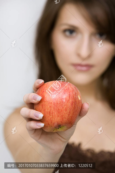 擺姿勢抱著紅蘋果的女孩