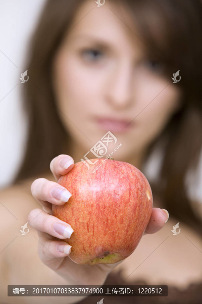 擺姿勢(shì)抱著紅蘋果的女孩