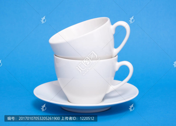 藍(lán)色背景上堆放的兩個(gè)白色咖啡杯
