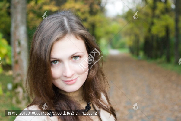 在秋天的公園里的年輕女人