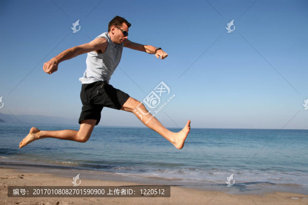 男子在海灘上跳