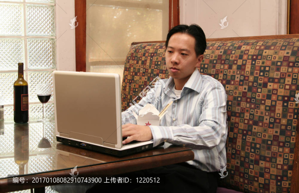 商務(wù)人士午餐時與筆記本電腦一起工作