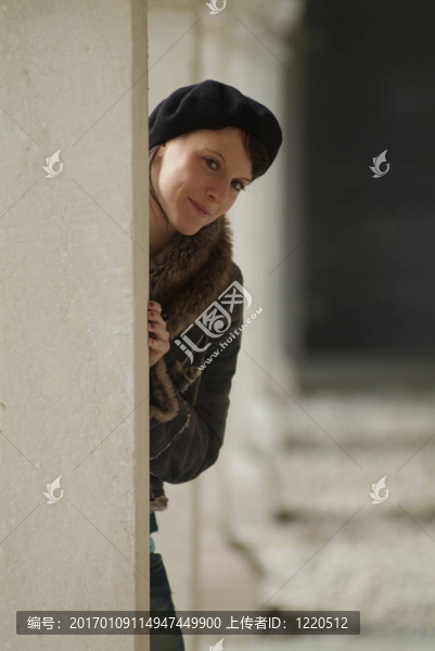 年輕的女人靠在柱子上