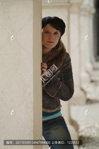 年輕的女人靠在柱子上