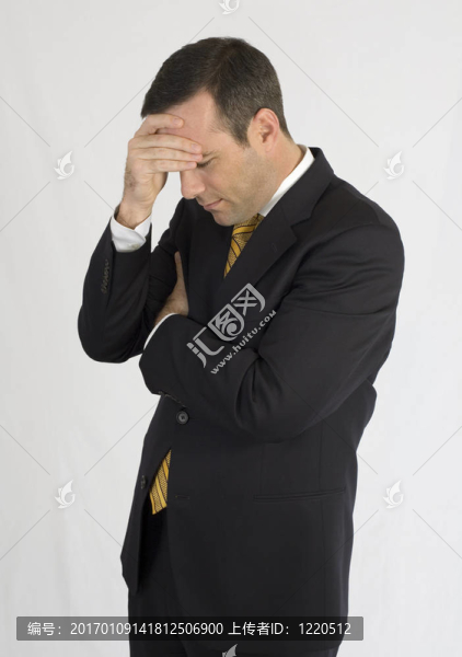 商人穿著黑色西裝，頭在手