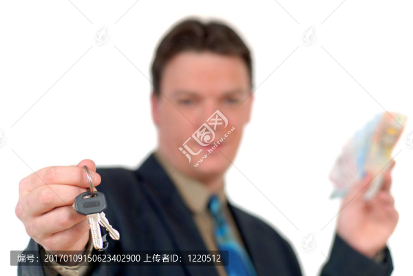 年輕的房地產(chǎn)經(jīng)紀(jì)人移交鑰匙；顯示錢