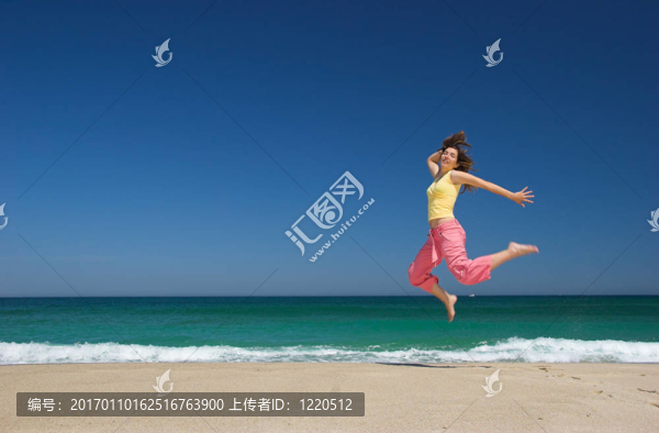 美麗的女人在海灘上跳