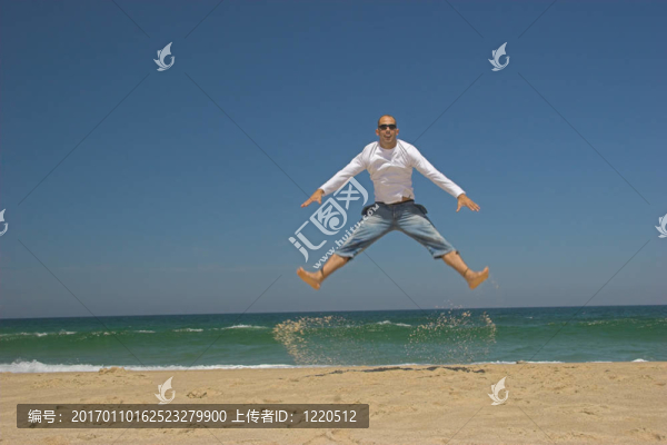 男子在海灘上跳