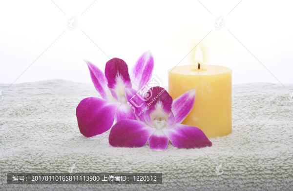 綠毛巾上的黃色蠟燭和蘭花