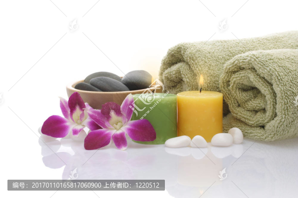 綠毛巾；蘭花；白色背景上的蠟燭和鵝卵石