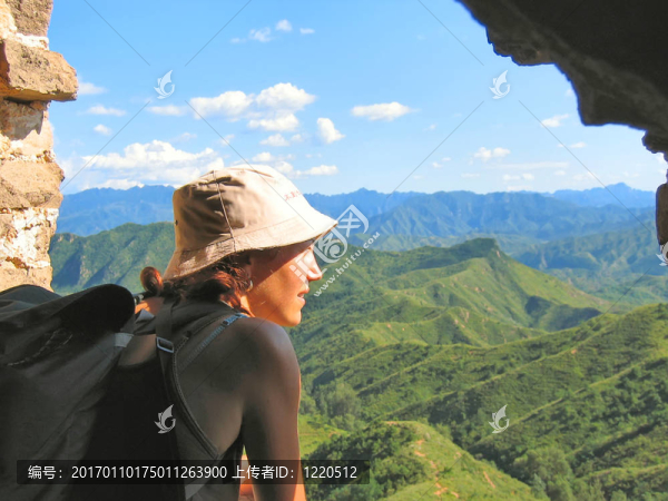 一個戴帽子的望山和長城中國叢林徒步旅行的女人；中國