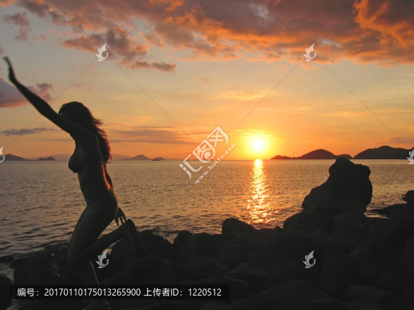 一個(gè)女人在運(yùn)動(dòng)中從剖面在日落；納閩下；有沙灘；弗洛里斯島；印度尼西亞