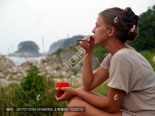 海灘上有咖啡和香煙的女孩