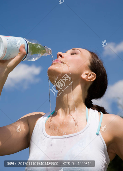 年輕的女人trinking水戶外