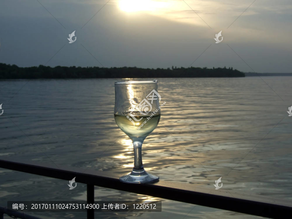 在河上落日的背景下的白葡萄酒