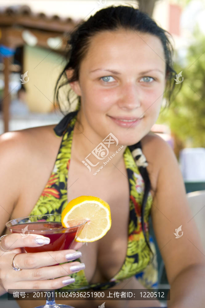 年輕美麗的微笑女人喝雞尾酒