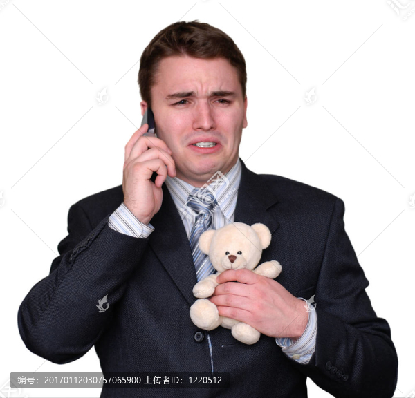 年輕商人在手機上哭泣，緊緊抓住Teddy,Bear。
