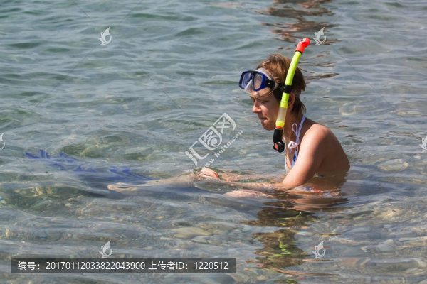 年輕的女人坐在潛水和鰭的水