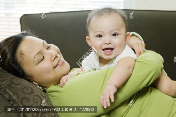 母親躺在沙發(fā)上擁抱Baby,Boy（6-9個月）