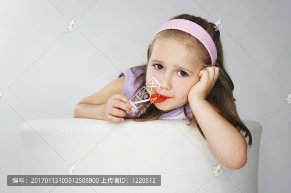 年輕漂亮的女孩在粉紅色背景光與棒棒糖