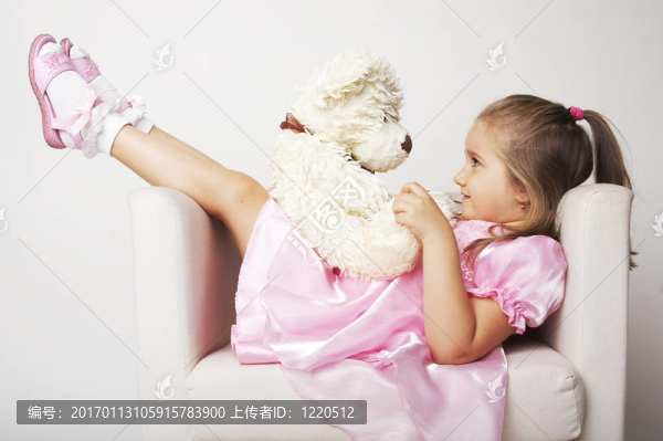 漂亮的年輕女孩在粉紅色背景與泰迪熊