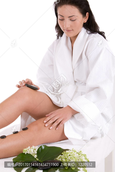 漂亮的女人給自己一個熱石按摩