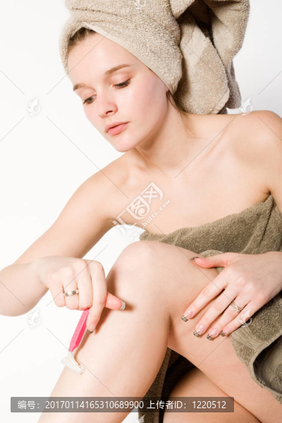 年輕的女孩在剃她的腿