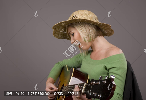 戴著帽子的金發(fā)美女在彈吉他