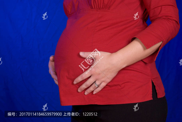懷孕的女人用手放在她的肚子上