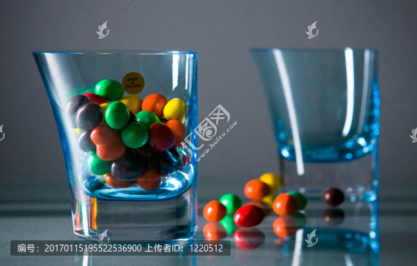 兩杯帶顏色的糖果在灰色的