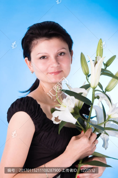 迷人的女人帶著一束百合花。