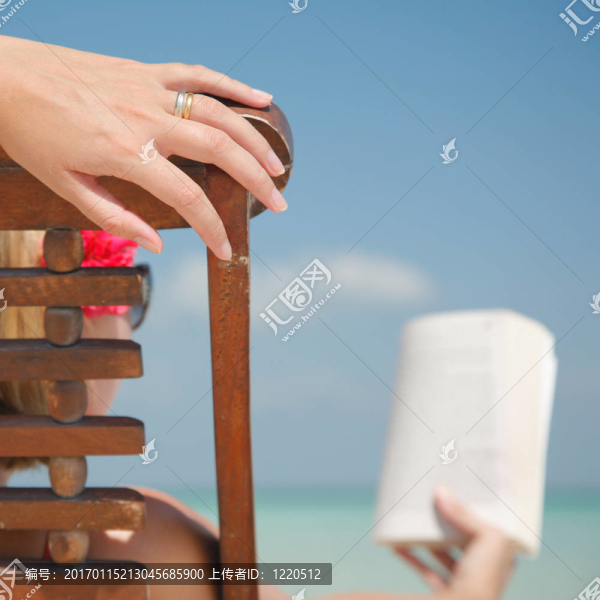 在躺椅上讀書的女人